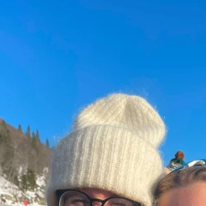 Vit ribbstickad mössa i ullmix - Supermysig vit ribbstickad mössa med uppvikt kant. Mössan är fluffig och har en oversized look, 