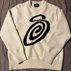 Stüssy Swirly S - En väldigt bekväm och skön stickad tröja från Stüssy som bara är använd ett par gånger. Tröjan säljs eftersom den inte riktigt passar mig. Den är knappt använd och i väldigt gott skick, enda skavanken som finns är att lappen i nacken lossnat i ett hörn.