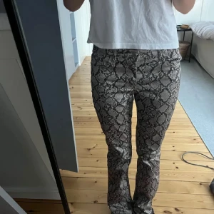 Bootcut byxor med ormmönster -  bootcut byxor från Weekday🖤Super sköna och snygga! Första bilden är ej min egen, vid fler bilder kom privat🥰pris kan diskuteras vid snabb affär!