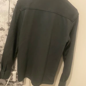 Grå overshirt från Blue Ridge - Snygg grå overshirt från Blue Ridge med två stora bröstfickor och klassisk krage. Skjortan har långa ärmar och knäppning framtill. Perfekt att slänga över en t-shirt för en chill look.