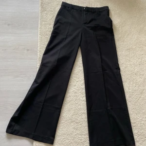Kostymbyxor - Från H&M. Helt nya fast prislappen är borttagen då jag först tänkte behålla byxorna, säljer då de sitter lite för tajt. Storlek 34. Low-mid waist och vida ben.