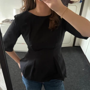 Svart topp - Jag säljer denna skitsnygga svarta toppen som funkar både i vardagen och vid festligare tillfällen!!💕 endast använd en gång! Kan skicka samma dag om du väljer instabox!