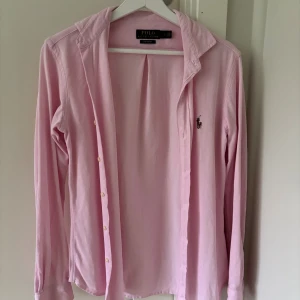 Rosa skjorta från Polo Ralph Lauren - Säljer en klassisk rosa skjorta från Polo Ralph Lauren. Den är i pikematerial och i strl S. Den har inte används så flitigt och är därför i väldigt fint skick. 