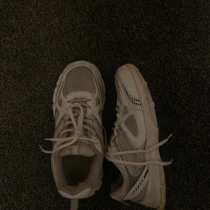 Vita mesh sneakers med snörning storlek 42 - Säljer ett par vita sneakers med sportig vibe och cool mesh-design. Skorna har snörning, detaljer i syntet och mesh samt en rejäl sula med svart mönster undertill. Perfekta för dig som gillar en clean och fräsch look till vardags.