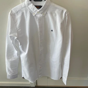 Vit skjorta från Morris - Säljer en vit Morris skjorta i ny skick i storlek M. Modellen är ca 180 cm lång. Hör av dig vid funderingar!