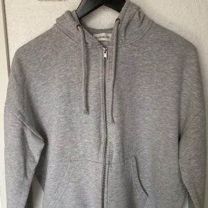 Grå hoodie med dragkedja från Even&Odd - Mysig grå hoodie från Even&Odd i storlek S. Tröjan har huva med snörning, hel dragkedja framtill och känguruficka. Tillverkad i mjuk bomullsblandning, perfekt för chill dagar eller när du vill vara extra bekväm.