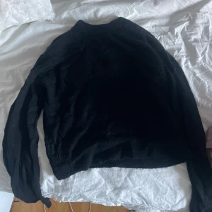 Svart stickad polotröja & Other Stories - Svart stickad tröja från & Other Stories med långärmad design. Tröjan är mjuk och har en klassisk, enkel look som funkar till många olika stilar. Perfekt för dig som gillar minimalistiskt och stilrent.