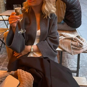 Grå kappa från nakd  - Säljer en stilren grå kappa från nakd som är slutsåld,  är tillverkad i mjuk ullmix. Storlek xs