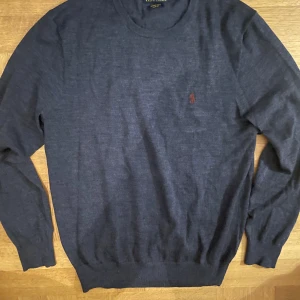 Mörkblå merinoullströja Polo Ralph Lauren - Snygg mörkblå stickad tröja från Polo Ralph Lauren i merinoull. Slim fit-modell med rund halsringning och diskret röd logga broderad på bröstet. Är stl L men passar M✅👊