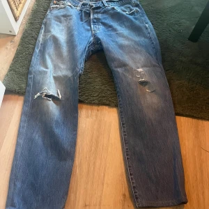 Levi's 501 blå jeans med slitningar - blå Levi's 501 jeans knappt använda.