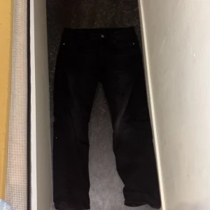 Svarta jeans från Kappahl - Svarta jeans från Kappahl i klassisk femficksmodell. Jeansen har rak passform och normal midja, tillverkade i ett mjukt bomullstyg med lite stretch för extra komfort. Perfekta för dig som gillar en enkel och stilren look. Pris kan diskuteras. 