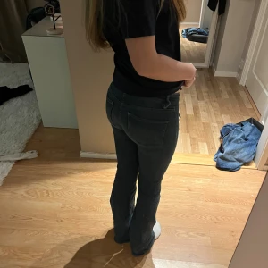 Bootcut jeans från Nelly i mörkblå - Snygga mörkblå bootcut jeans från Nelly med låg midja. Jeansen har klassiska fickor fram och bak, markerade sömmar och är tillverkade i stretchigt denim för en bekväm passform. Perfekta för dig som gillar en retroinspirerad look.