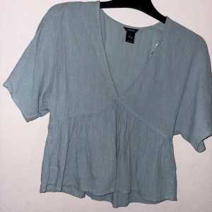 Blus från Lindex - Säljer en ljusblå blus från Lindex med v-ringad hals och korta ärmar.Storlek XS. Hör av er vid funderingar!!💕