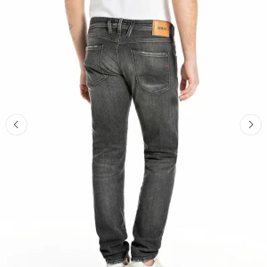Replay gråa jeans - Snygga gråa jeans från Replay med tvättad och något sliten look. Klassisk femficksmodell, normal passform och raka ben. Jeansen har Replay-lapp bak i midjan och coola detaljer vid fickorna. Perfekta för dig som gillar en avslappnad men stilren vibe.