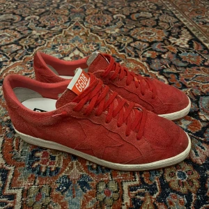 Röda golden goose ballstar - Riktigt feta golden goose ballstar, dessa är i bra skick me tanke på att golden goose ofta har söndrig sula men dessa har en helt fin sula. Dem kostar flera tusen nya därav e mitt pris riktigt bra. Mått: Innersula:27,5cm