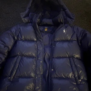 Mörkblå dunjacka Polo Ralph Lauren - Säljer en mörkblå dunjacka från Polo Ralph Lauren i storlek XL vilket motsvarar 155-159