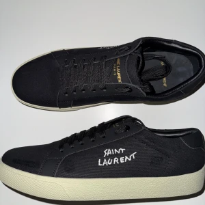 Svarta Saint Laurent sneakers - Helt nya Saint Laurent skor i färgen svart och vitt. Skorna är 43 men storleken är liten sả det passar någon som bär storlek 42. Riktigt bra material pả dem och skorna är jätte sköna pả. Helt nya, aldrig använd med snygg minimalistisk design som passar till allt.