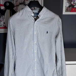 Ralph Lauren skjorta - Vi säljer nu denna extremt fina skjortan från Ralph Lauren i size M (slim fit).  Cond 8,5/10 (en liten fläck vid ena armen som knappt är synlig)  Nypris: 1599 kr - Vårt pris: 549 kr.  Endast skjortan som medföljer vid köp.  Snabba och enkla affärer prioriteras i vanlig ordning.