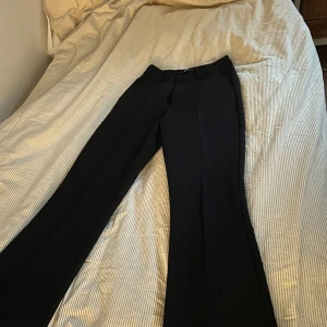 Svarta kostymbyxor från Bik Bok - Aldrig använda. Säljer pga bara legat i garderoben. Snygga svarta kostymbyxor från Bik Bok i storlek 34. Klassisk midja och diskreta fickor bak. Perfekta för en clean och stilren look. Nypris var ungefär 400 -550