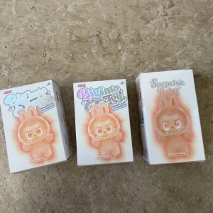 Pop Mart Biginto Energy Surprise Baby - Säljer tre oöppnade Pop Mart Biginto Energy Surprise Baby samlarfigurer. Kartongerna är i nyskick utan synligt slitage. Perfekt för samlare eller som present. Varje box innehåller en överraskningsfigur i kanindräkt med söta detaljer.