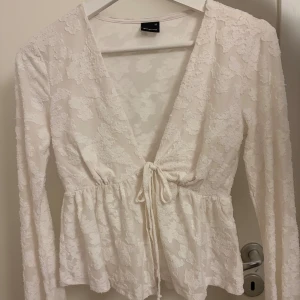 Vit blus från Gina  - Vit blus med mönster och knytning. Använd max 1 gång 
