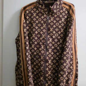 Brunmärkes tracksuit  - Säljer en brun märkes tracksuit med ikoniskt monogrammönster i beige över hela koftan. Den kommer med byxor 