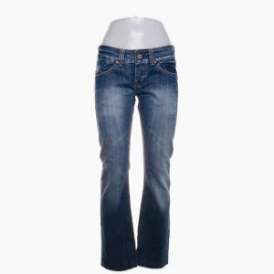 Lågmidjade jeans från Yes Miss, stl 28 - Snygga Lågmidjade blå jeans från Yes Miss med raka ben och coola slitningar. Bakfickorna har broderade detaljer i beige och jeansen har klassisk femficksdesign. Perfekta för dig som gillar en avslappnad men trendig look.