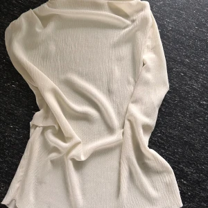 Vit långärmad blus från Zara - Säljer en stilren vit blus från Zara i storlek S. Blusen har lång ärm och är tillverkad i ett lätt, strukturerat tyg som ger en snygg och luftig känsla. Perfekt att matcha med jeans eller kjol för en clean look.