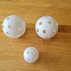 3 stycken innebandybollar - Diameter stora bollar 7 cm. En av dem har text made in Sweden.   Diameter lilla boll 4 cm. Har text taiwan.