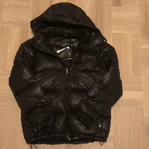 Ralph lauren jacka  - Tja! Säljer denna sprillans nya svarta Ralph lauren jacka. Sjukt varm och stilren, perfekt inför vintern. Helt oanvänd med original tags på, storlek M. Hör av er vid eventuella frågor eller funderingar! 