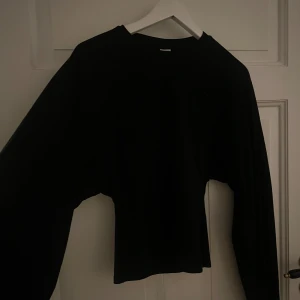Svart långärmad tröja med smal midja - Svart långärmad tröja med rund hals och smalare midja som ger en snygg siluett. Materialet känns mjukt och stretchigt, perfekt för dig som gillar enkel och stilren look. Är i nyskick och har endast använts några få gånger säljs för mer än 100 kr mindre än vad jag köpte den för.