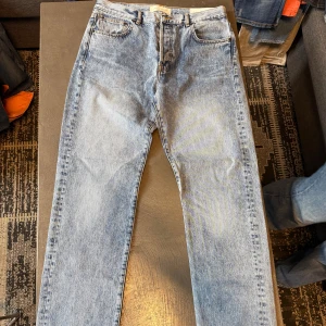 Ljusblå jeans från Jeanerica DM004 - Säljer ett par ljusblå jeans från Jeanerica, modell DM004. Klassisk femficksdesign med raka ben och normal passform. Jeansen har snygga kontrastsömmar och är tillverkade i slitstarkt bomullsdenim. Perfekt för dig som gillar en clean och tidlös look.