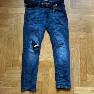 Mörkblå slim-fit jeans - Riktigt snygga mörkblå slim-fit jeans. W33/L30. Några skavanker (se bild) men märks inte mycket vid användning.