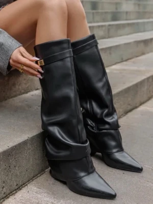 Svarta slouchy boots med spetsig tå - Hej! Säljer ett par svarta boots i slouchy modell med spetsig tå och klacken är rätt så hög. Skorna är gjorda i blankt skinnliknande material och har en dekorativ rem med guldfärgat spänne upptill. Perfekta för dig som vill ha en edgy och trendig look. Storlek är 41 men är mindre i storlek så passar mig som annars har 40 vanligtvis. 🩷Dom har använts 1-2 ggr, säljer då jag har användning för andra boots mer än dessa