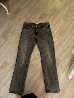 Grå raka jeans från Zara, strl 38 - Säljer ett par grå jeans från Zara i storlek 38. Jeansen har rak passform, klassisk femficksdesign och normal midja. Materialet är denim i bomull och färgen är tvättad grå med en lite vintage look. Perfekta till sneakers eller boots.