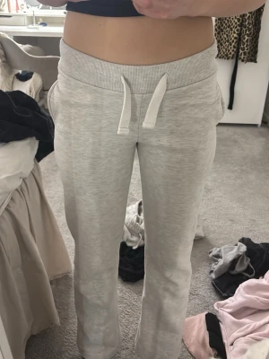 grå mjukisbyxor Gina tricot - Säljer ett par ljusgrå mjukisbyxor med vita snören o tryck på fickorna. Säljer eftersom dom är för korta för mig tråkigt nog, jag är 171cm. Storlek xs❤️🥰 jag brukar ha xs-S i byxor och passar mig bra förutom i längden. Knappt använda 