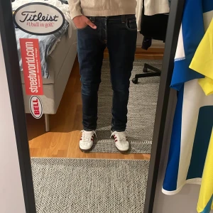 Mörkblå jeans från Nudie W30 L30 - Snygga mörkblå jeans från Nudie med klassiska sömmar och Nudie-logga på bakfickan. Modellen har fem fickor och normal passform i midjan. Perfekt för dig som gillar stilrena jeans. W30 L30 Hör av dig vid frågor och funderingar! 👍🤝                                      Mvh Edvin 