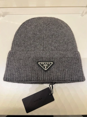 Prada  mössa - Säljer en helt ny Prada mössa i färgen grå. Postar inom 24 tim 📦🚚