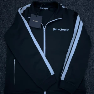 Palm Angels Zip-Up - Plagg:Palm Angels Zip-Up Storlek:S Passar M Mitt pris:699 Skick:10/10 Helt Ny Märke/Brand:Palm Angels Färg:Svart/Vit Passform:S-M Övrigt:Hel Ny Aldrig Använd  Fraktar Inom 24 h📦 Skriv Vid Minsta Lilla Intresse😃 