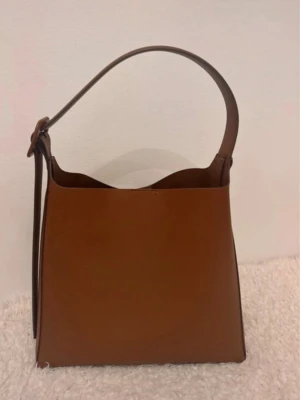 Brun väska från Mango - Brun stor väska från Mango. Använd några gånger. Liten repa under väskan. Se bild. Annars gott skick 