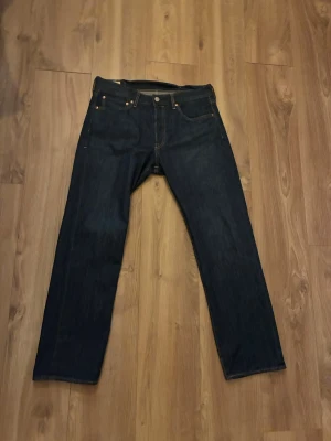 Levi's 501 mörkblå jeans straight fit - 50 ettor. Använda kanske 4 gånger. Säljs pga att jag snabbt växte ur dem. Storlek är W 32 L30. Skriv bara ni har nån fråga eller vill diskutera pris🫠