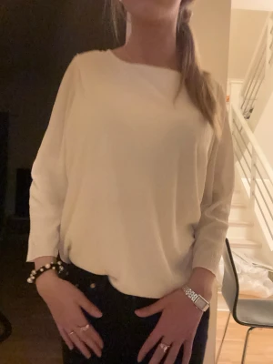 Vit långärmad blus med lös passform - En stilren vit blus med kortare ärm och rund halsringning. Modellen är loose och passar perfekt till både jeans och kjol. Enkel och tidlös design som är lätt att matcha med olika outfits.