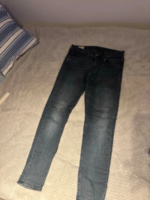 Levi's 512 Slim Jeans mörkblå 31/32 - Säljer ett par Levi's 512 slim jeans i mörkblå. Storlek 31/32  Klassisk modell med dragkedjegylf och snygga slitningar längs benen. Perfekta för dig som gillar en smalare passform och tidlös stil. 