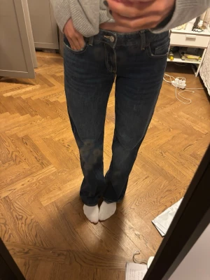 Mörkblå raka jeans från zara - Klassiska mörkblå jeans från zara med rak passform och normal midja. Jeansen har fem fickor och subtila kontrastsömmar. Perfekta för en avslappnad och stilren look.