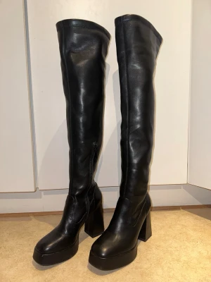 Svarta overknee platåstövlar - Säljer ett par svarta overknee stövlar med chunky platå och bred klack.  Used once in very good condition. Brandnew price cost around 1,300kr selling it for less price. it 40 but fit is 38