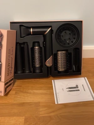 Multi Styler 6-in-1 hårstyler - Säljer Professional 6-in-1 med flera utbytbara tillbehör för hårstyling från RUSTA. Nypris är 1000kr. Setet innehåller bland annat rundborste, locktillbehör och fönmunstycke. Allt levereras i originalförpackning med manual. Locktängerna och rundborsten är endast använd fåtal gånger och övriga stycken är aldrig använda.❤️