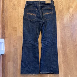 Nudie jeans Flare Glenn - Säljer ett par sliskiga Nudie Jeans i modellen Flare Glenn! Storlek 30/30. Tvätten är ”dry nostalgia” som helt enkelt innebär att de aldrig har tvättats. Dessa är knappt använda o köpta på nudie jeans affär för bara några veckor sedan. Därav är de i ett förträffligt skick! Mått: Längd ca 105 cm, Midja ca 40 cm, Benöppning ca 26 cm. Nypris 1600kr -Mitt pris 1399kr prutat och klart ✅. Har du frågor är det bara att hojta till!