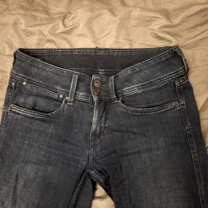 Mörka blå pepe jeans  - Säljer ett par mörk blå pepe jeans bootcut/straight. Dem är super low waist och har två knappar fram till. 26-34 är stoleken. 