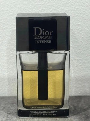 Dior Homme Intense Eau de Parfum - Dior Homme Intense Eau de Parfum är en lyxig herrdoft i en stilren, fyrkantig glasflaska med svart lock. Parfymen har en gyllene vätska och flaskan rymmer 50 ml. En klassisk och elegant doft från Dior, perfekt för dig som gillar exklusiva parfymer. Skulle gissa på 38 ml kvar