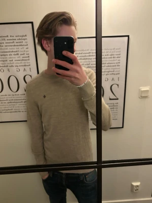 Morris tröja  - Säljer en beige Morris Crewneck i 100% merinoull. Jag på bilden är 174cm o väger 58kg. Hör av er om ni har några frågor.